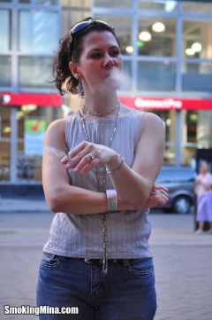 Brunette babe smoking while loitering on the street - N