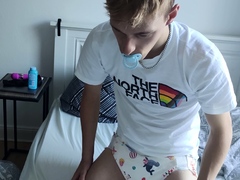 young padded boy with pacifier wears sweet diaper, fills her